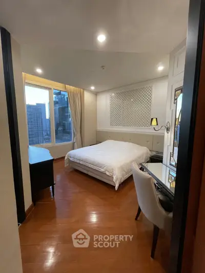 Luxurious bedroom with city view, elegant decor, and hardwood floors in a high-rise apartment.