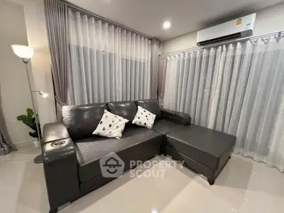 Modern living room with sleek black leather sofa and stylish decor