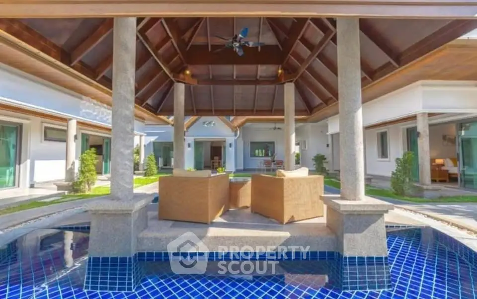 Luxurious villa with open-air living area and private pool, showcasing elegant architecture and serene ambiance.