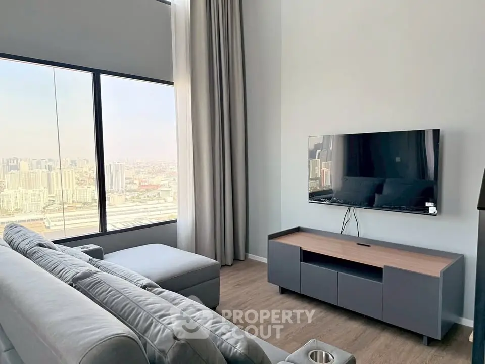 Modern living room with city view, featuring sleek furniture and large windows for natural light.