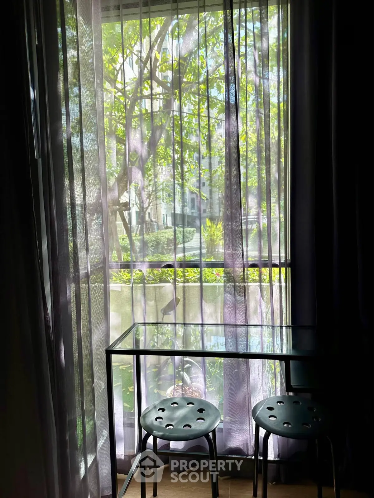 Charming interior view with natural light through sheer curtains and modern seating, perfect for relaxation.