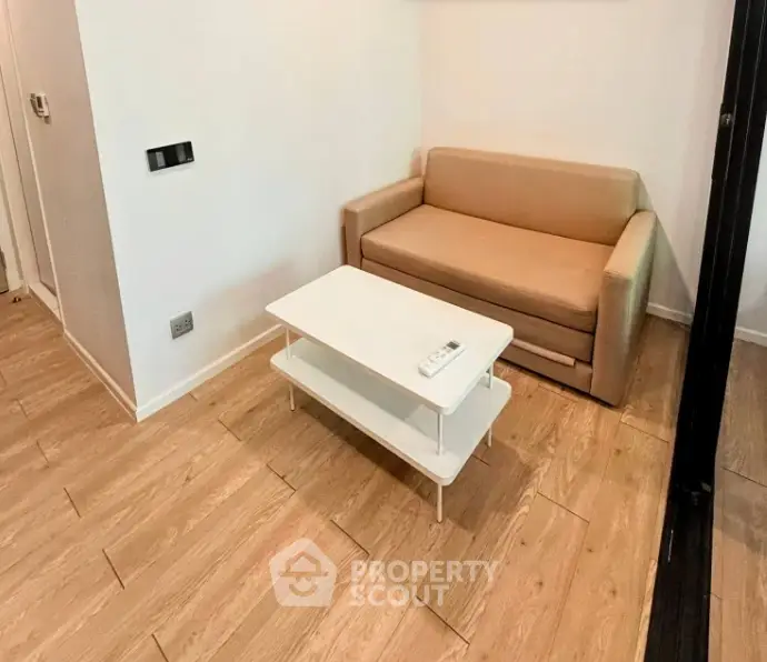 Cozy living room with modern sofa and sleek coffee table on wooden flooring.