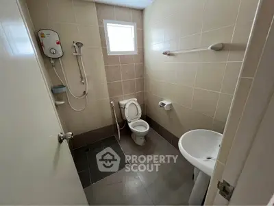 Modern bathroom with shower, toilet, and sink in a compact layout.