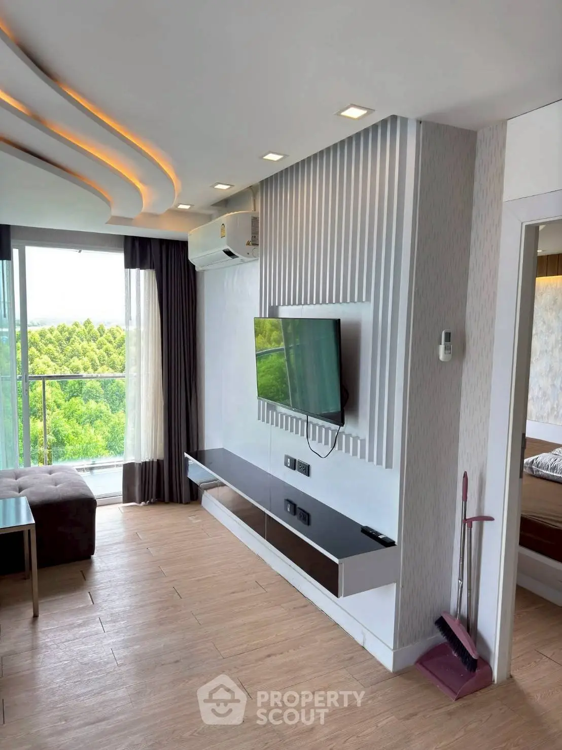 Modern living room with sleek TV setup and scenic balcony view