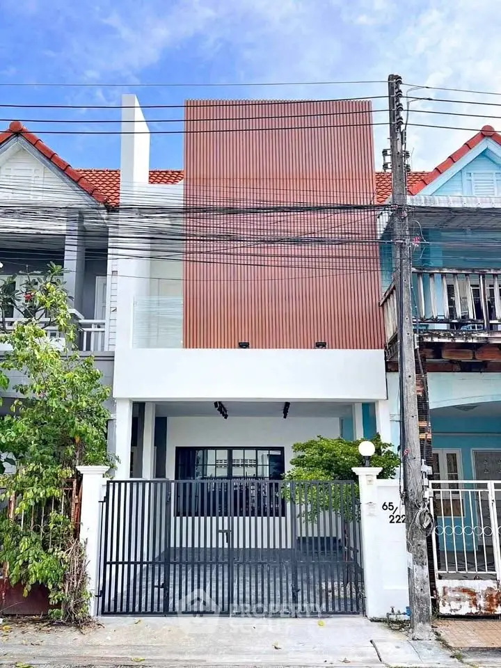 Modern townhouse exterior with gated entrance and contemporary facade design.