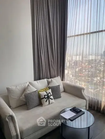 Luxurious living room with elegant sofa and panoramic city view through large windows.