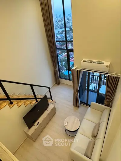 Modern loft-style living room with city view and balcony access, featuring sleek furniture and large windows.