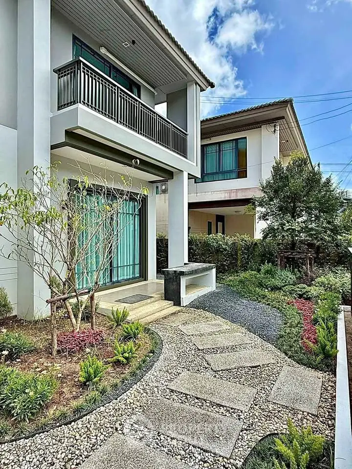 Charming modern house with landscaped garden and inviting entrance pathway.