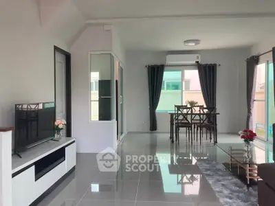 Modern living room with sleek furniture and dining area, featuring large windows and stylish decor.