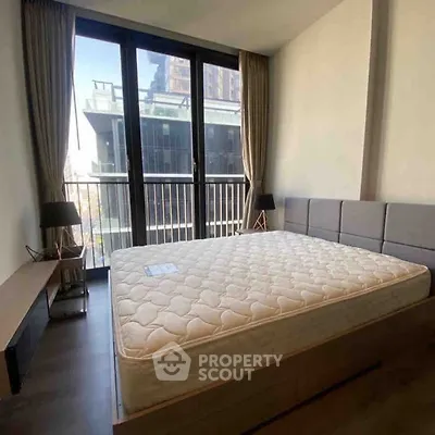 Spacious bedroom with large windows and modern decor in urban apartment