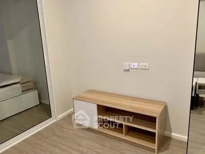 Modern bedroom with sleek wooden storage unit and mirrored closet doors