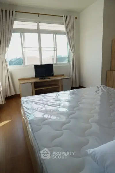 Bright bedroom with large window and modern furnishings