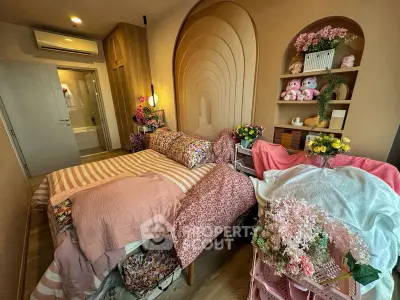 Charming bedroom with cozy decor and floral accents, featuring a comfortable bed and stylish lighting.