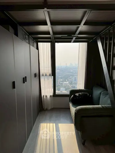 Stylish loft apartment with panoramic city view and cozy seating area.