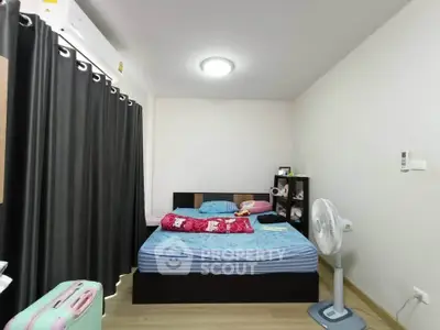 Cozy bedroom with modern decor and ample natural light, featuring a comfortable bed and stylish furnishings.