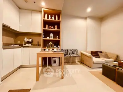 Modern open-layout kitchen and cozy living room with stylish decor and ample lighting.