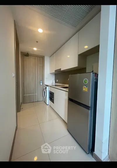 Modern kitchen with sleek appliances and ample storage in a stylish apartment.