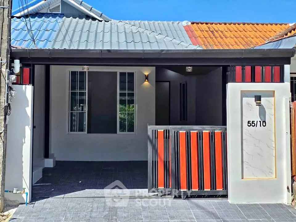 Charming single-story home with modern facade and gated entrance, perfect for cozy living.