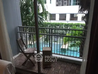Charming balcony with pool view in modern apartment complex