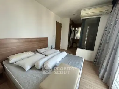 Modern bedroom with wooden flooring and air conditioning unit