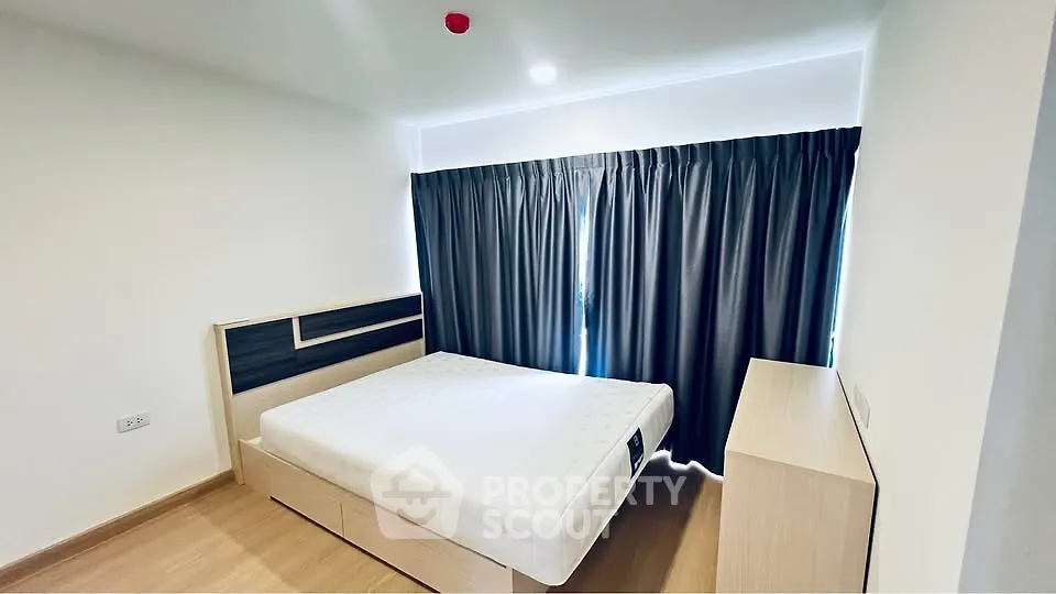 Modern bedroom with minimalist design and large window with blackout curtains.