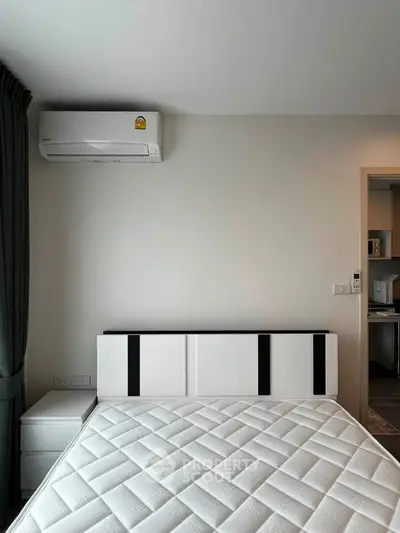 Modern bedroom with sleek design and air conditioning unit, showcasing minimalist style and comfort.