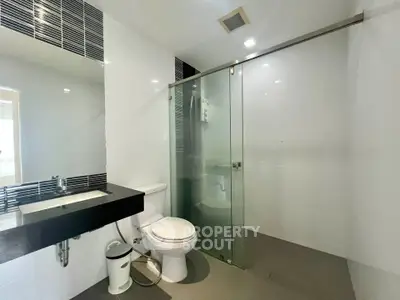 Modern bathroom with glass shower and sleek black countertop