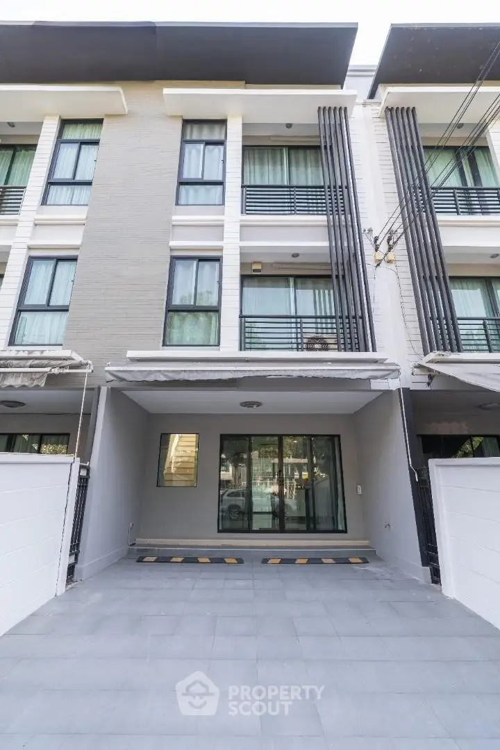 Modern townhouse exterior with sleek design and spacious driveway