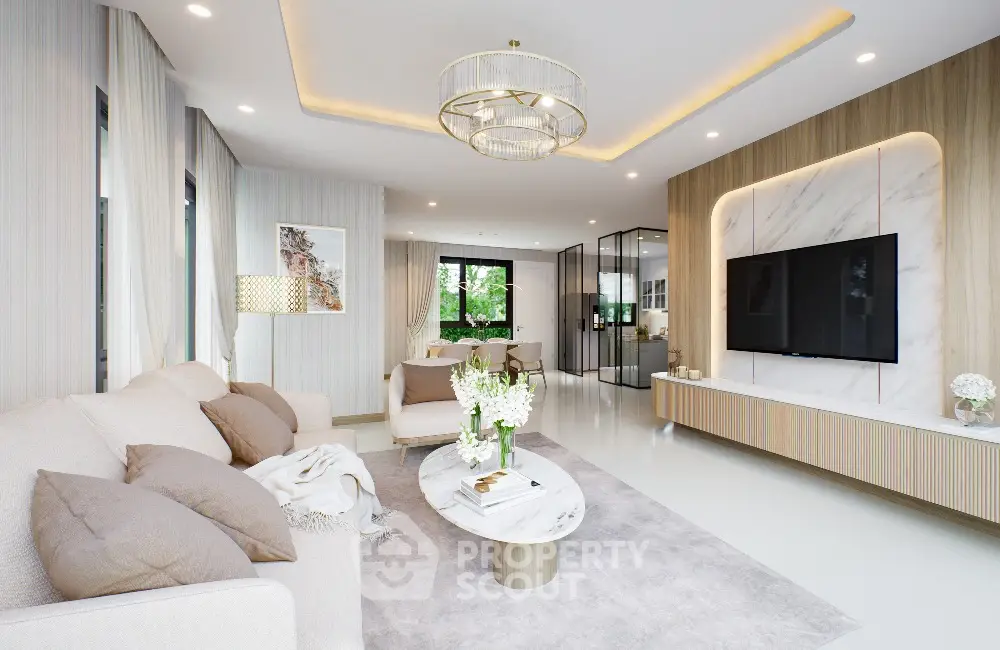 Luxurious modern living room with elegant decor and large TV, featuring a stylish chandelier and cozy seating area.