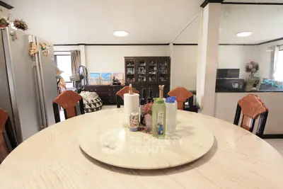 Spacious dining area with elegant round table and stylish chairs in a cozy home setting.