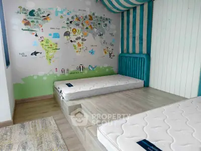 Charming children's bedroom with playful world map mural and cozy mattresses on raised platform.