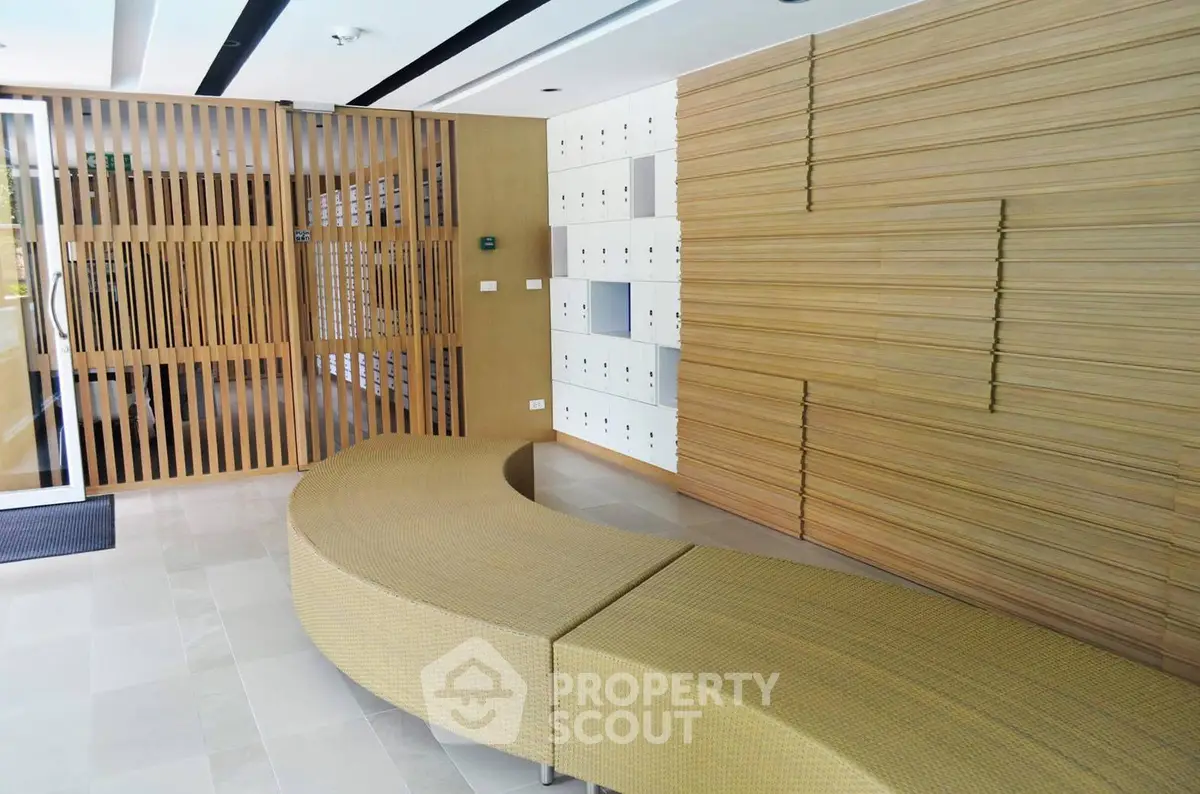 Modern building entrance with stylish wooden paneling and curved seating area.