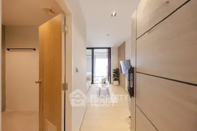 Modern apartment hallway leading to a bright living room with stylish decor and natural light.
