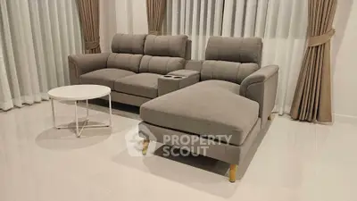 Modern living room with stylish gray sectional sofa and elegant curtains