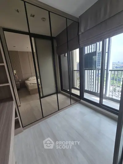 Modern bedroom with mirrored wardrobe and balcony view
