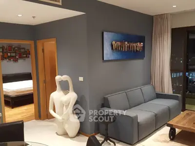Modern living room with stylish decor and art, featuring a cozy sofa and unique sculpture.