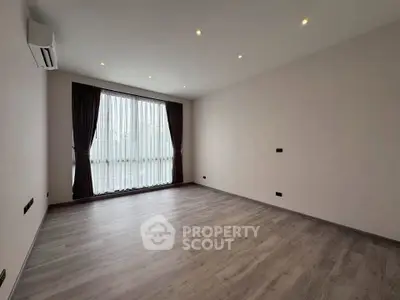 Spacious empty room with large window and elegant curtains, perfect for customization.