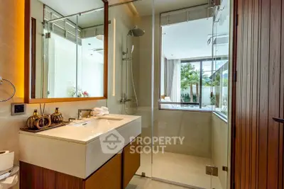 Luxurious modern bathroom with glass shower and elegant wooden accents