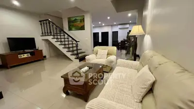 Spacious living room with elegant staircase and cozy seating area