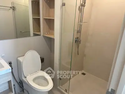 Modern bathroom with glass shower and sleek fixtures in a contemporary apartment.