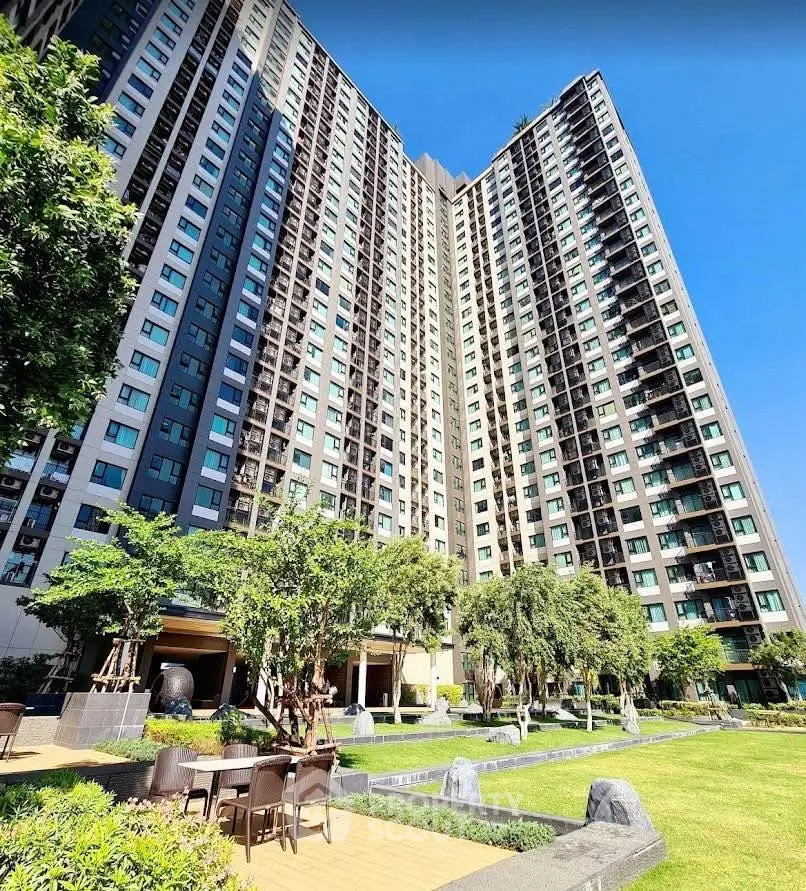 Stunning high-rise building with lush garden and outdoor seating area