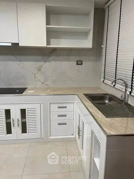 Modern kitchen with sleek white cabinetry and marble countertops