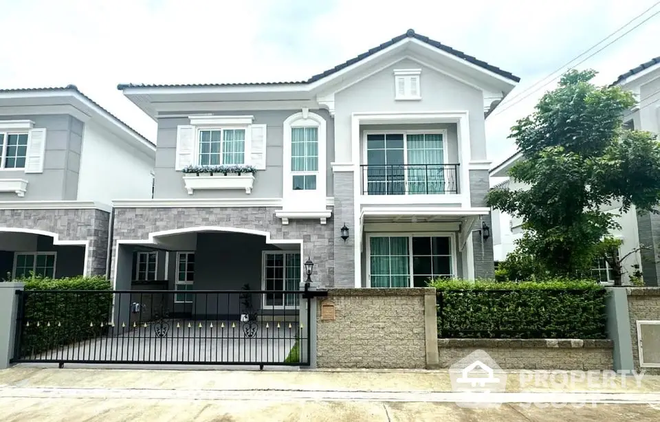 Elegant two-story house with modern facade and lush greenery