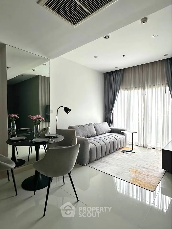 Modern living room with sleek furniture and large window for natural light.