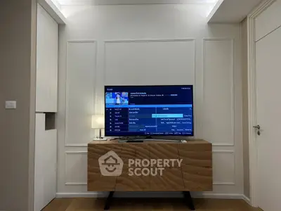Modern living room with stylish wooden TV stand and wall-mounted flat screen TV.