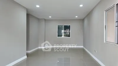 Spacious empty room with modern tile flooring and large window, perfect for customization.