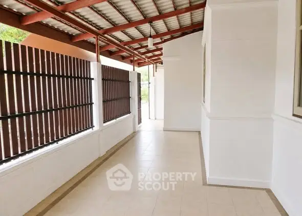 Spacious covered outdoor corridor with tiled flooring and modern design.