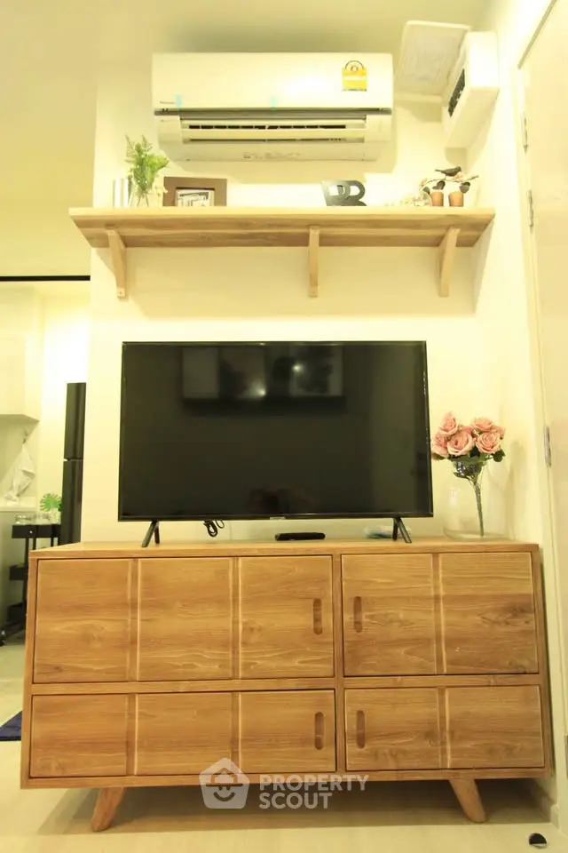 Modern living room with wooden TV stand, wall-mounted shelf, and air conditioner.