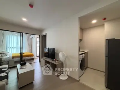 Modern apartment interior with open living room and kitchen, featuring sleek furniture and natural light.