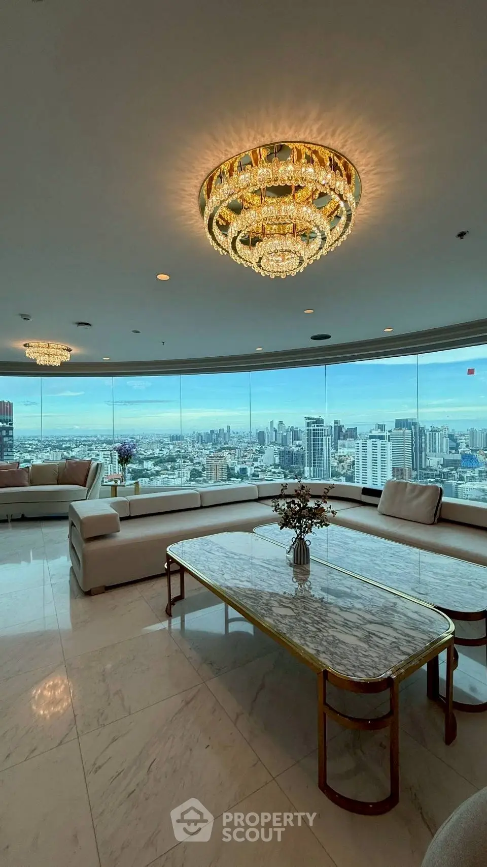 Luxurious living room with panoramic city view and elegant chandeliers.